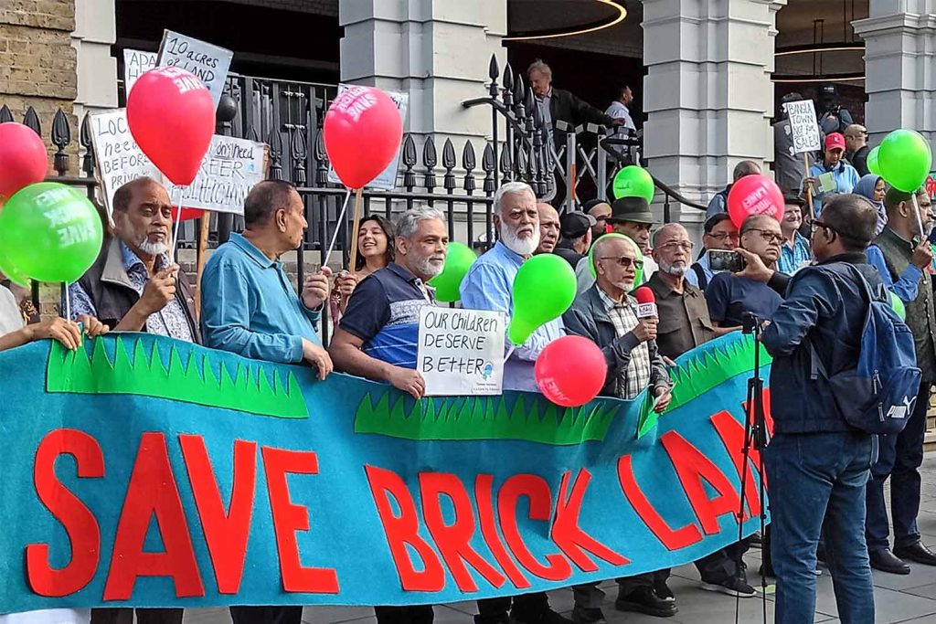 Campaigners demonstrate outside Tower Hamlets Town Hall holding signs which read 'Save Brick Lane' and 'Our Children Deserve Better'