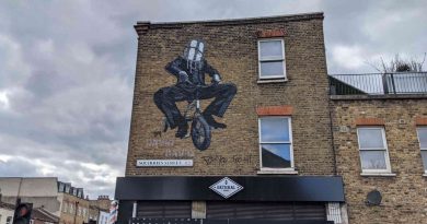 Mural of a man cycling with a paint bucket on his head