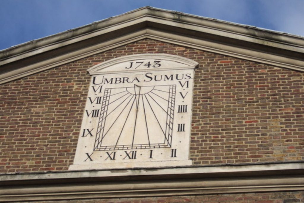 A stone sundial inscribed with ‘Umbra Sumus’, mounted on Brick Lane Mosque, Fournier Street, Bethnal Green