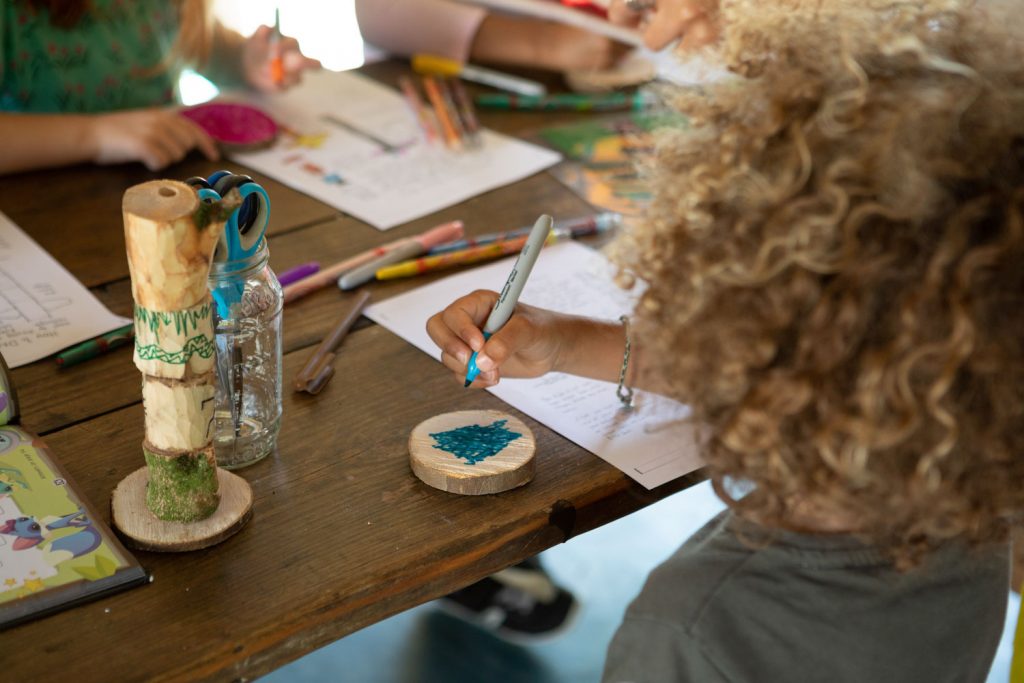 A young child is drawing during a summer workshop at Spitalfields City Farm