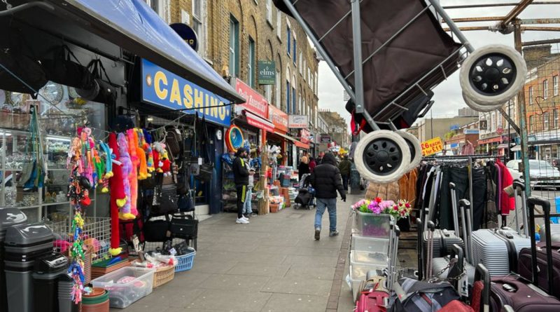 Walking through the streets of Bethnal Green with market stalls on the right.