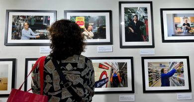 Woman looking at Sarah Ainsley's photography exhibition, Women at Work in Bethnal Green, at Oxford House.