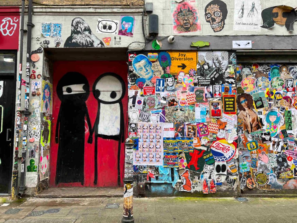 Street art on Princelet Street depicting a couple holding hands, one wearing a burka, by the artist Stik.