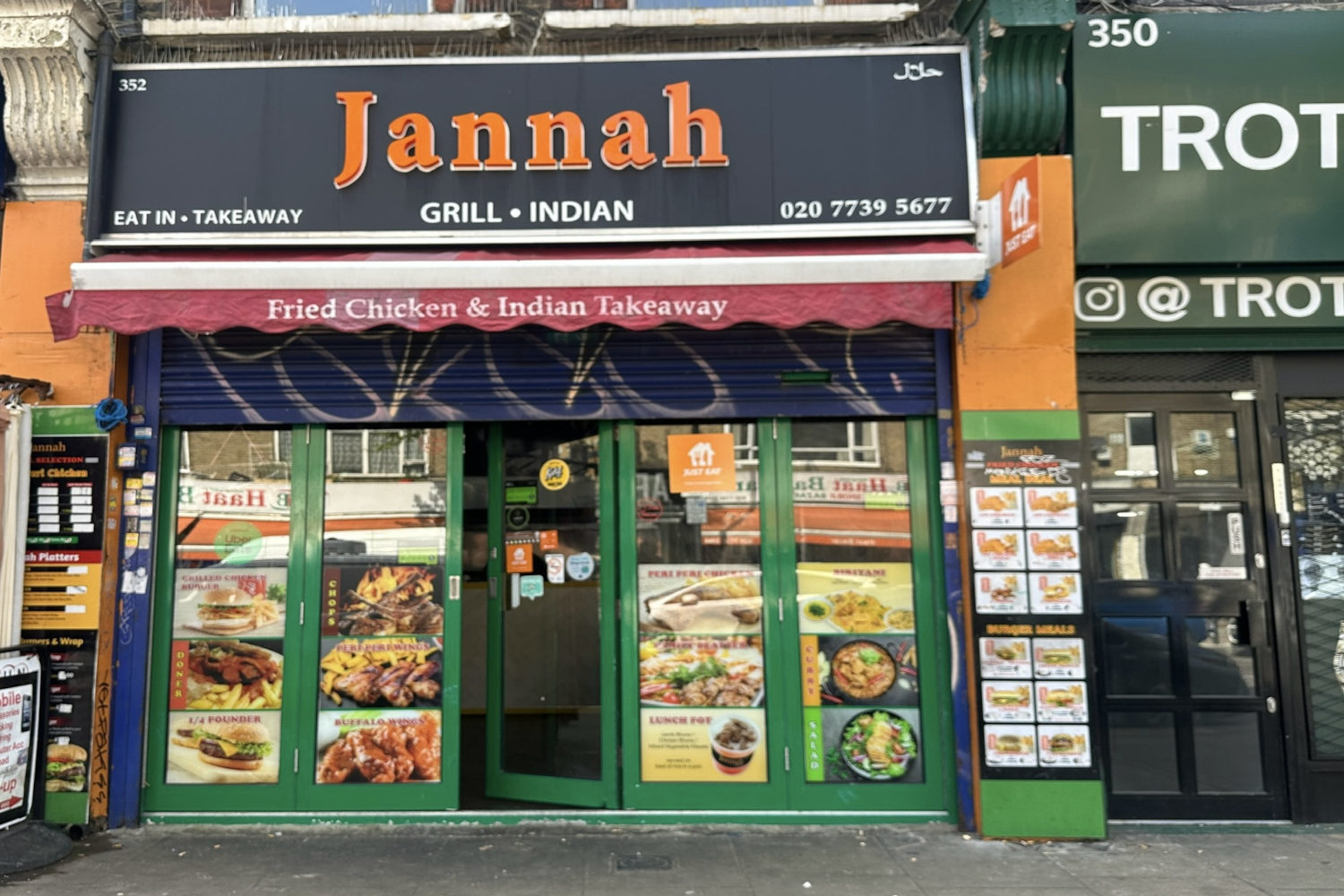 Jannah Grill shop front with bright orange lettering and menu leaflets stuck onto the windows.